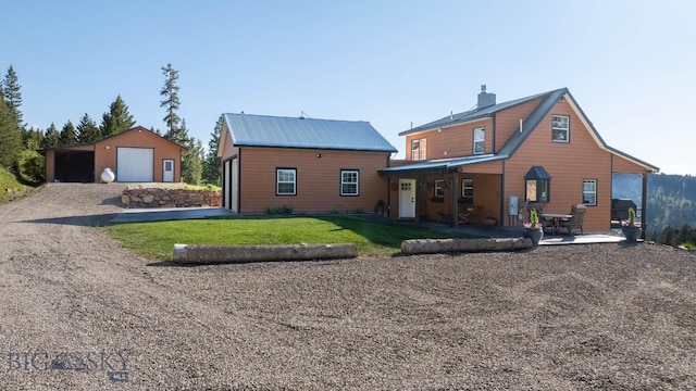 185 Peak, Bozeman, MT 59715 - back of house with a garage, an outbuilding, a lawn, and driveway