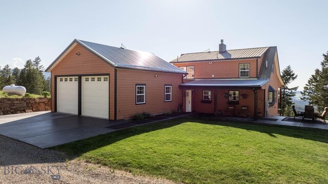 185 Peak, Bozeman, MT 59715 - back of house featuring a chimney, a lawn, a metal roof, and an outbuilding