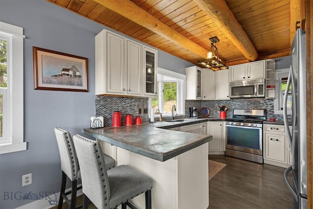 185 Peak, Bozeman, MT 59715 - kitchen with stainless steel appliances, a wood ceiling with exposed beams, a peninsula, decorative backsplash, and a chandelier