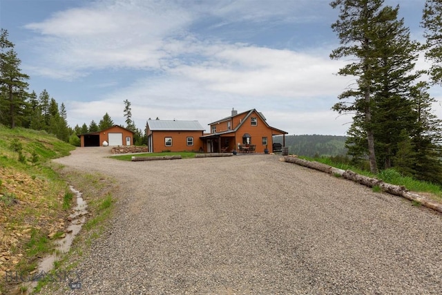 185 Peak, Bozeman, MT 59715 - view of front of property featuring driveway, an outbuilding, a detached garage, and a chimney