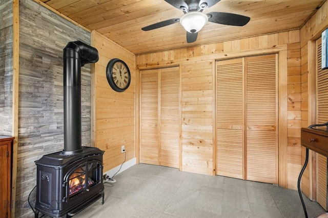 185 Peak, Bozeman, MT 59715 - unfurnished living room with wood ceiling, wood walls, a wood stove, and a ceiling fan