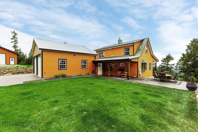 185 Peak, Bozeman, MT 59715 - rear view of property featuring a lawn, a garage, a chimney, and an outbuilding