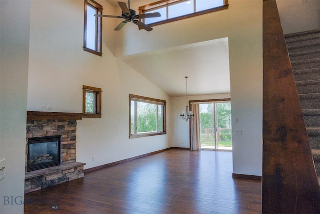 3230 S 26th Ave, Bozeman, MT 59718 - unfurnished living room featuring a towering ceiling, wood finished floors, a ceiling fan, a stone fireplace, and stairs