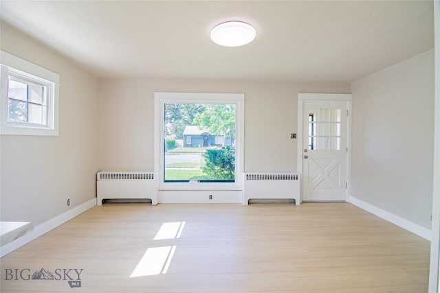 1940 Locust, Butte, MT 59701 - unfurnished room with radiator heating unit, plenty of natural light, and light wood-type flooring