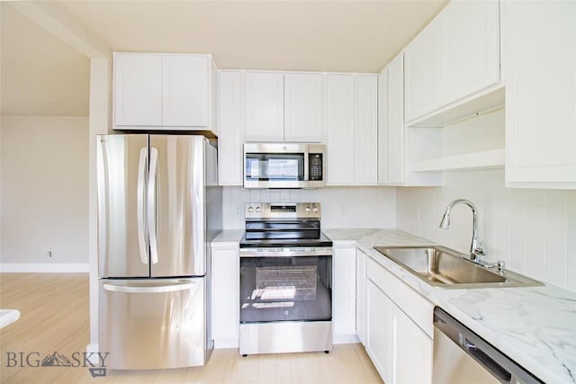 1940 Locust, Butte, MT 59701 - kitchen featuring appliances with stainless steel finishes, backsplash, light stone counters, and white cabinetry