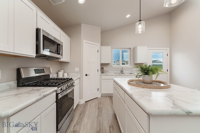 2204 Oriole Dr, Belgrade, MT 59714 - kitchen with stainless steel appliances, light wood finished floors, white cabinetry, recessed lighting, and hanging light fixtures