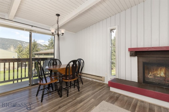139 Spruce Cone Dr Unit 14, Big Sky, MT 59716 - dining space featuring baseboard heating, a tiled fireplace, beamed ceiling, plenty of natural light, and wood finished floors