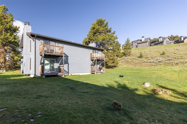 139 Spruce Cone Dr Unit 14, Big Sky, MT 59716 - back of house with a chimney, a yard, and a wooden deck