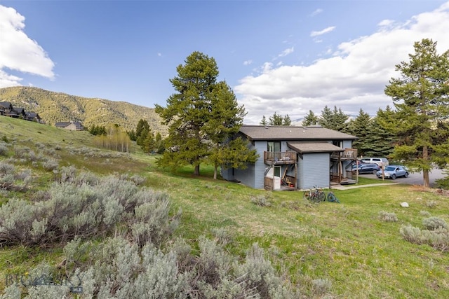 139 Spruce Cone Dr Unit 14, Big Sky, MT 59716 - view of green lawn featuring a deck with mountain view