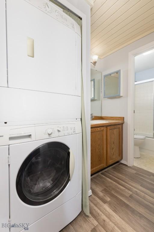 139 Spruce Cone Dr Unit 14, Big Sky, MT 59716 - washroom with estacked washer and dryer, wooden ceiling, and wood finished floors