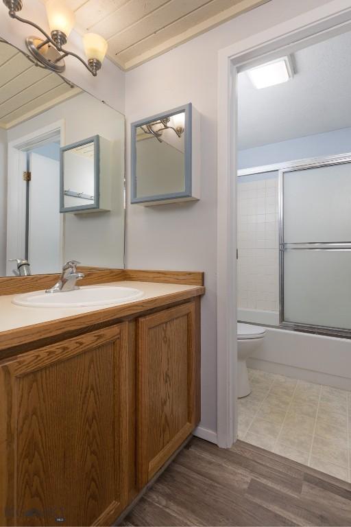 139 Spruce Cone Dr Unit 14, Big Sky, MT 59716 - bathroom with vanity, combined bath / shower with glass door, wood finished floors, and a chandelier