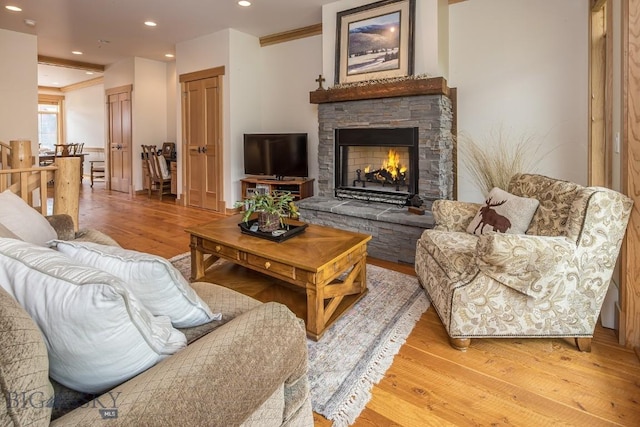 2500 Little Coyote Rd Unit 34, Big Sky, MT 59716 - living room featuring light wood-style flooring, a stone fireplace, ornamental molding, and recessed lighting