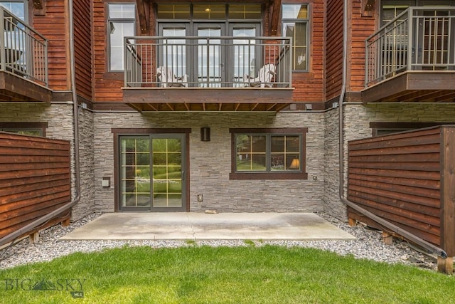 2500 Little Coyote Rd Unit 34, Big Sky, MT 59716 - back of property featuring stone siding, a balcony, and a patio area