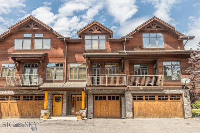 2500 Little Coyote Rd Unit 34, Big Sky, MT 59716 - view of front of home with a garage, a balcony, driveway, and stone siding
