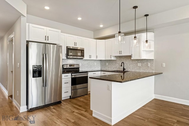 6707 Blackwood Rd Unit C, Bozeman, MT 59715 - kitchen featuring stainless steel appliances, a peninsula, tasteful backsplash, dark wood-type flooring, and recessed lighting