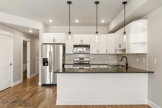 6707 Blackwood Rd Unit C, Bozeman, MT 59715 - kitchen featuring stainless steel appliances, open shelves, dark stone countertops, tasteful backsplash, and a peninsula