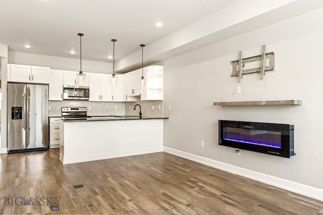 6707 Blackwood Rd Unit C, Bozeman, MT 59715 - kitchen with stainless steel appliances, dark countertops, white cabinets, recessed lighting, and backsplash