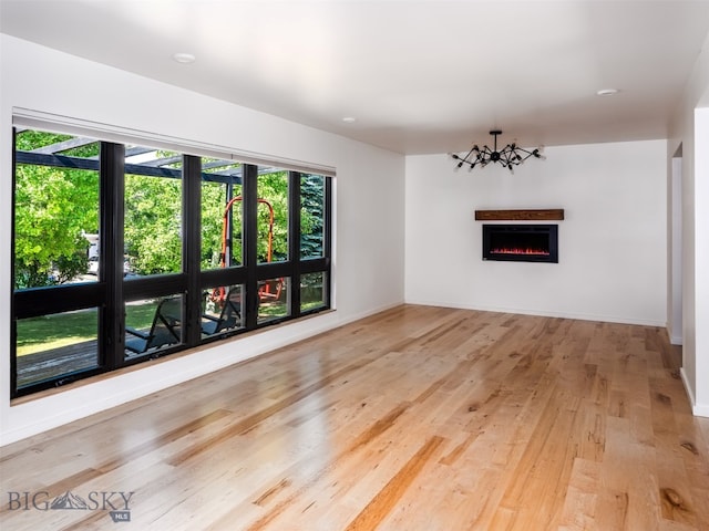 1206 N Cedarview Dr, Bozeman, MT 59715 - unfurnished living room with a warm lit fireplace and light wood-style flooring