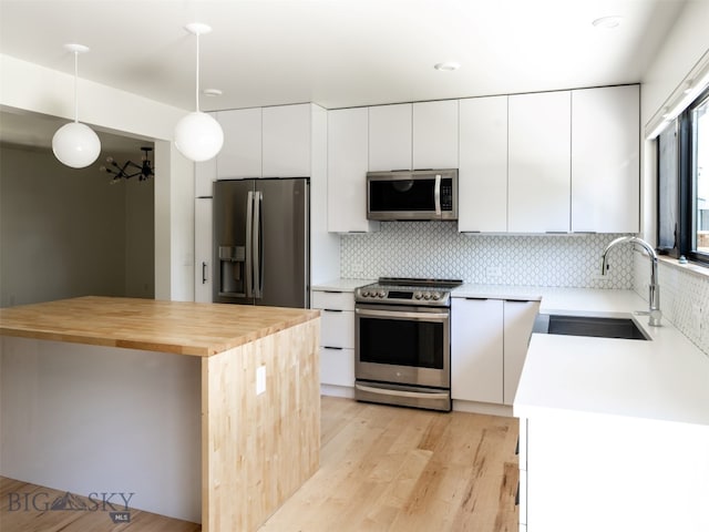 1206 N Cedarview Dr, Bozeman, MT 59715 - kitchen with appliances with stainless steel finishes, white cabinets, tasteful backsplash, and light wood finished floors
