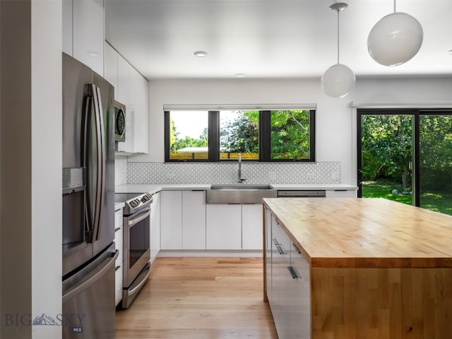 1206 N Cedarview Dr, Bozeman, MT 59715 - kitchen with appliances with stainless steel finishes, butcher block counters, modern cabinets, white cabinets, and backsplash