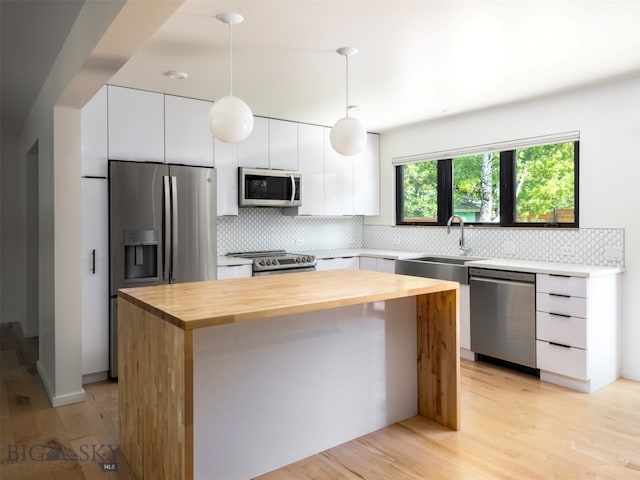 1206 N Cedarview Dr, Bozeman, MT 59715 - kitchen featuring stainless steel appliances, butcher block counters, tasteful backsplash, and white cabinets