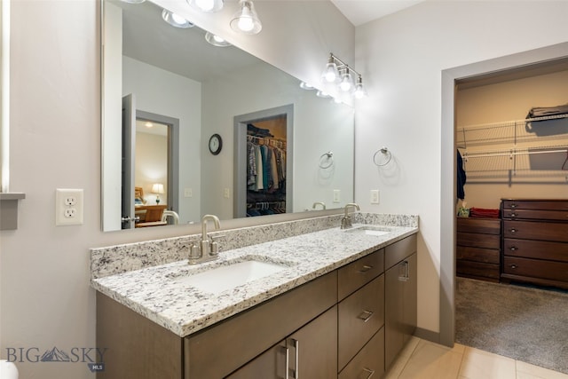 1308 Scooter Ln, Belgrade, MT 59714 - bathroom featuring double vanity, a walk in closet, and tile patterned floors