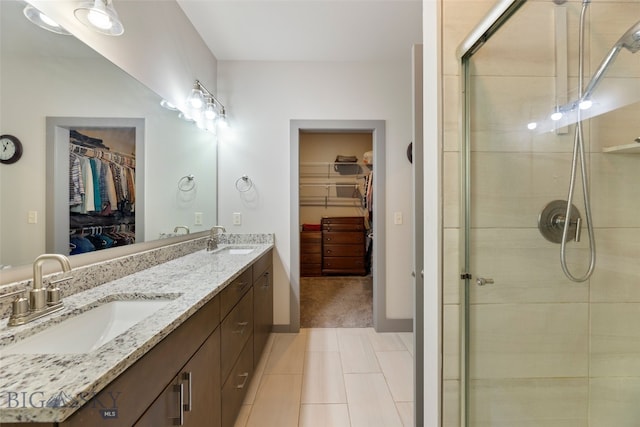 1308 Scooter Ln, Belgrade, MT 59714 - bathroom with a spacious closet, double vanity, a stall shower, and tile patterned floors