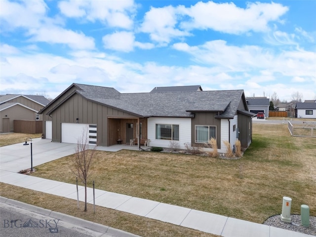 1308 Scooter Ln, Belgrade, MT 59714 - view of front of house with board and batten siding, driveway, an attached garage, and a front yard