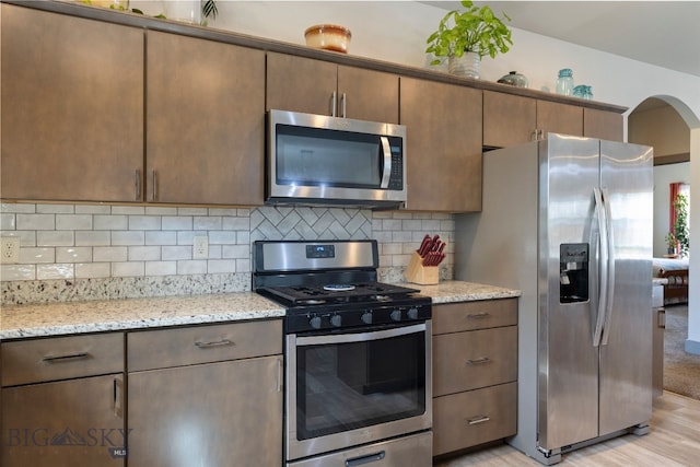 1308 Scooter Ln, Belgrade, MT 59714 - kitchen featuring appliances with stainless steel finishes, tasteful backsplash, and light stone counters