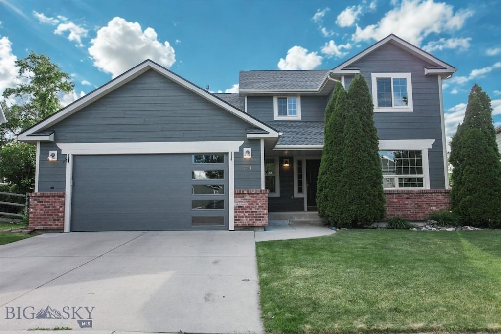 721N Aster Ave, Bozeman, MT 59718 - view of front of home with brick siding, driveway, a garage, and a front lawn