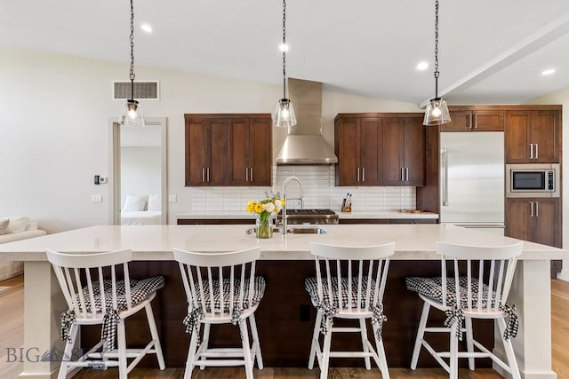 20 Caymus Ln Unit D, Bozeman, MT 59718 - kitchen with wall chimney exhaust hood, built in appliances, lofted ceiling, tasteful backsplash, and a large island