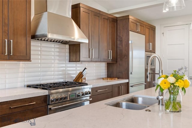 20 Caymus Ln Unit D, Bozeman, MT 59718 - kitchen with wall chimney exhaust hood, high end appliances, decorative backsplash, and light stone counters