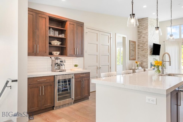 20 Caymus Ln Unit D, Bozeman, MT 59718 - kitchen with beverage cooler, open shelves, tasteful backsplash, light wood finished floors, and decorative light fixtures