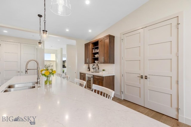 20 Caymus Ln Unit D, Bozeman, MT 59718 - kitchen featuring open shelves, wine cooler, pendant lighting, backsplash, and brown cabinetry