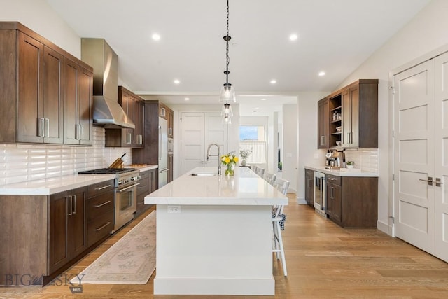 20 Caymus Ln Unit D, Bozeman, MT 59718 - kitchen with wall chimney range hood, high end appliances, open shelves, beverage cooler, and light wood-style floors