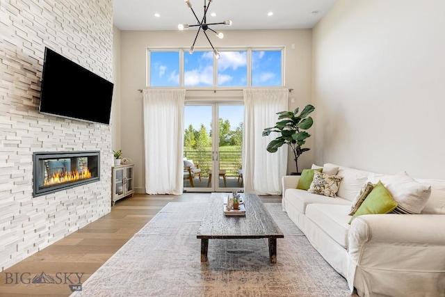 20 Caymus Ln Unit D, Bozeman, MT 59718 - living area featuring a towering ceiling, wood finished floors, a chandelier, a fireplace, and recessed lighting