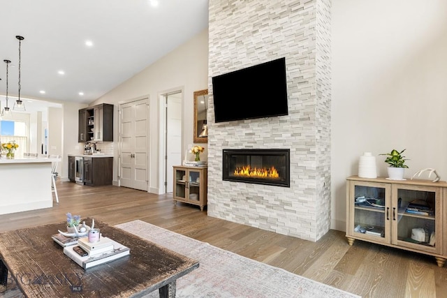 20 Caymus Ln Unit D, Bozeman, MT 59718 - living area featuring lofted ceiling, wood finished floors, beverage cooler, a fireplace, and recessed lighting