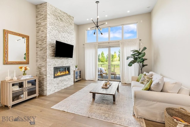 20 Caymus Ln Unit D, Bozeman, MT 59718 - living room with a towering ceiling, plenty of natural light, a large fireplace, a chandelier, and wood finished floors