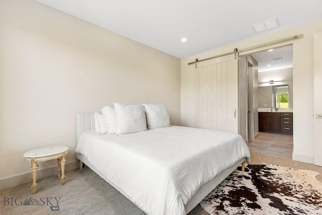 20 Caymus Ln Unit D, Bozeman, MT 59718 - bedroom with a barn door, ensuite bath, recessed lighting, and light carpet
