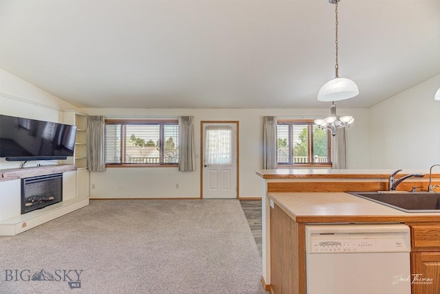 513 Burnham Pl, Helena, MT 59601 - kitchen with white dishwasher, vaulted ceiling, a fireplace, decorative light fixtures, and a chandelier
