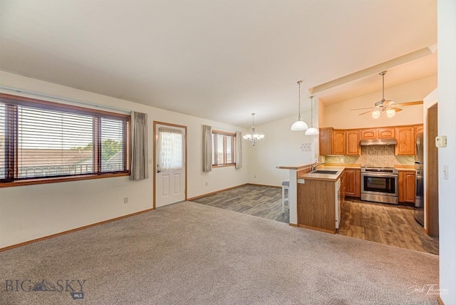 513 Burnham Pl, Helena, MT 59601 - kitchen featuring stainless steel range with electric stovetop, carpet, vaulted ceiling, open floor plan, and under cabinet range hood