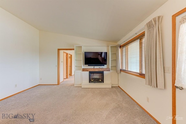 513 Burnham Pl, Helena, MT 59601 - unfurnished living room featuring a fireplace with raised hearth, light colored carpet, and vaulted ceiling