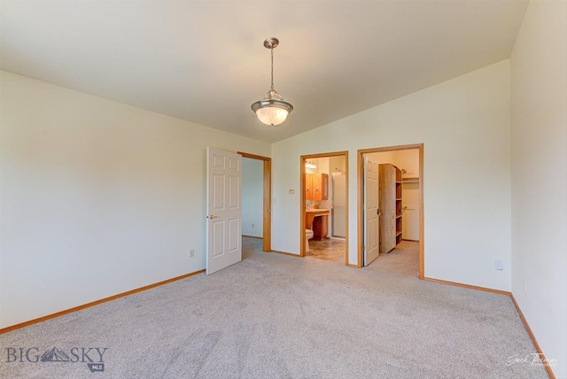 513 Burnham Pl, Helena, MT 59601 - unfurnished bedroom featuring light colored carpet, a spacious closet, connected bathroom, lofted ceiling, and a closet