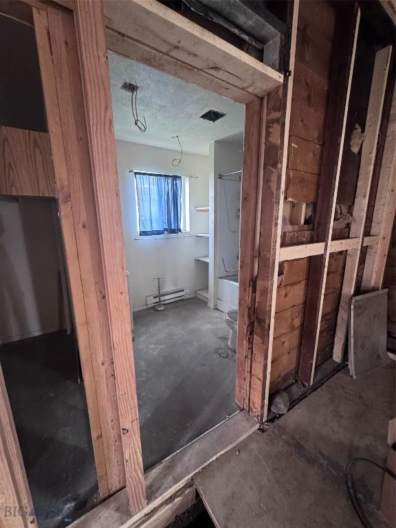 422 S Colorado, Butte, MT 59701 - miscellaneous room featuring a baseboard radiator and concrete flooring