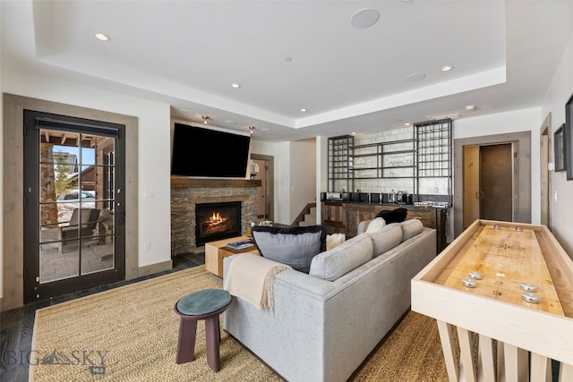 77 Tanager Frk Unit 29, Big Sky, MT 59716 - living room featuring a tray ceiling, recessed lighting, a fireplace, and bar