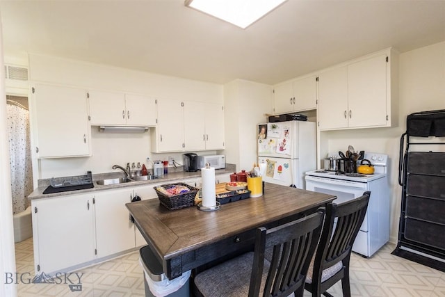 721 W Park Ave, Anaconda, MT 59711 - kitchen with white appliances, light flooring, white cabinets, and light countertops