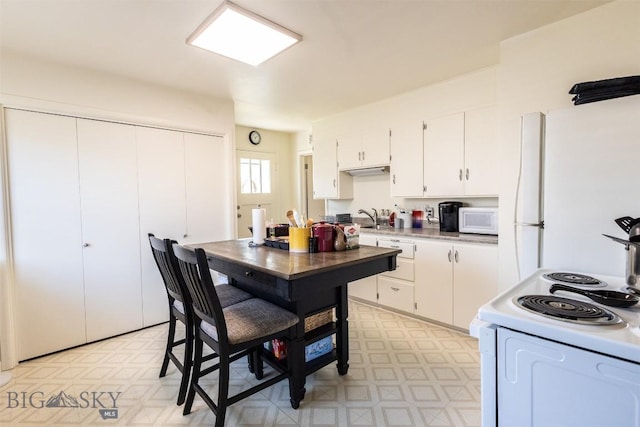 721 W Park Ave, Anaconda, MT 59711 - kitchen featuring white appliances, light floors, white cabinetry, and light countertops