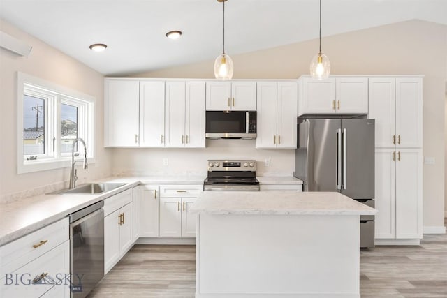 2305 S Colorado, Butte, MT 59701 - kitchen featuring appliances with stainless steel finishes, vaulted ceiling, light wood-style flooring, white cabinetry, and a kitchen island