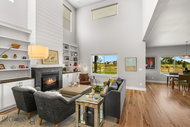 85 Riparian Way, Bozeman, MT 59718 - living room featuring a high ceiling, healthy amount of natural light, light wood-style flooring, and a fireplace