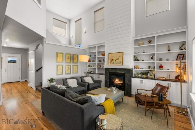 85 Riparian Way, Bozeman, MT 59718 - living room featuring light wood finished floors, a towering ceiling, a fireplace, and stairway